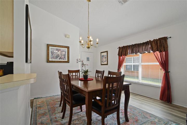 Spacious living and dining areas offer NEW LUXURY VINYL PLANK FLOORS (2023) for easy maintenance and sliding glass door access to the lanai and pool!