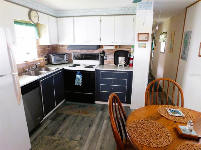 Kitchen has updated countertop, newer dishwasher, electric range, and laminate flooring.