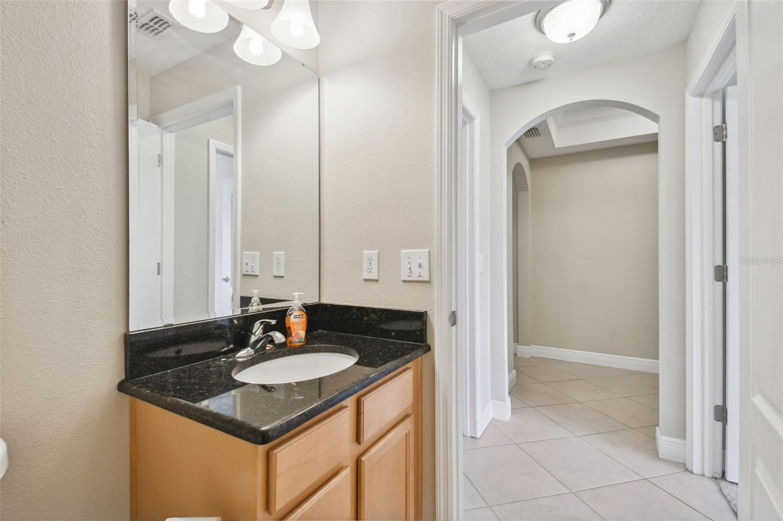 2nd bathroom vanity with view into hallway. Nice architectural arches in the hallways too