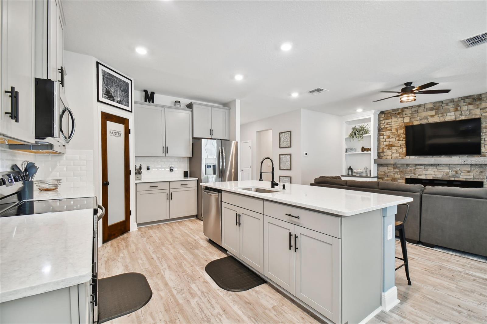 42" upper cabinets afford plenty of storage space, along with the walk-in pantry. Gleaming quartz counters.