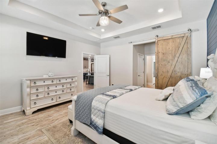 The custom barn door leads to two walk-in closets and the en-suite master bath.