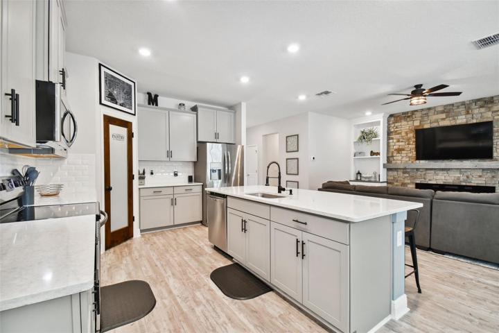 42" upper cabinets afford plenty of storage space, along with the walk-in pantry. Gleaming quartz counters.