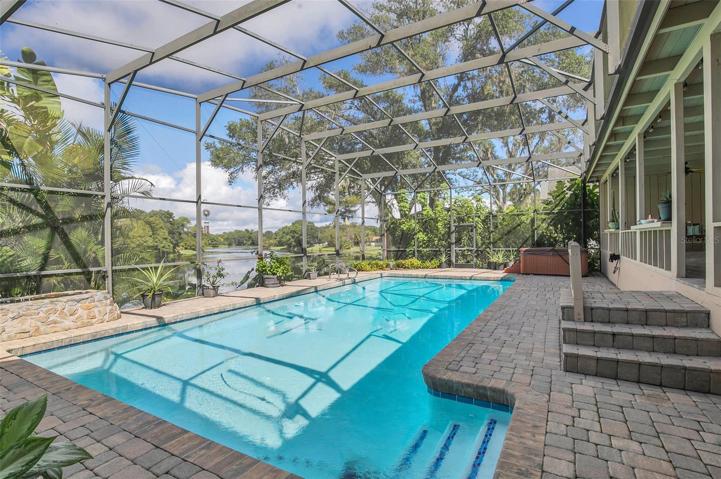 Screened in pool and above ground spa with brick paver decking and 2 garden fountains