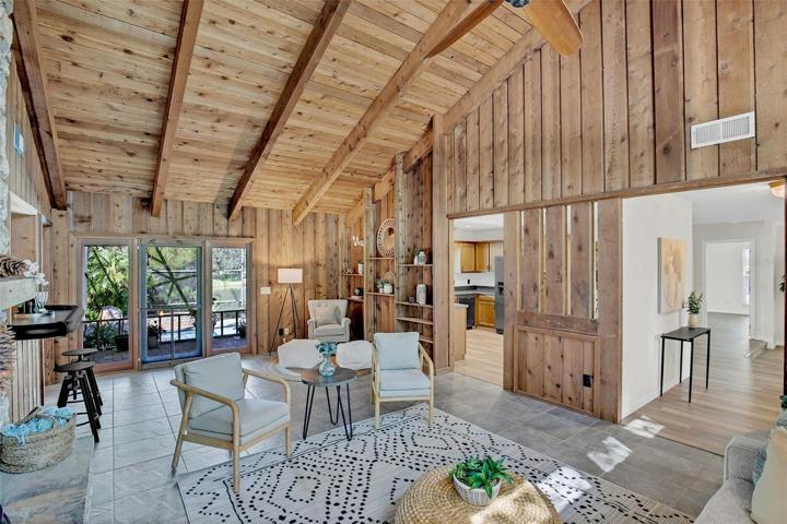 Family room featuring over 15' vaulted ceilings with gorgeous beams, cedar walls and built in shelving
