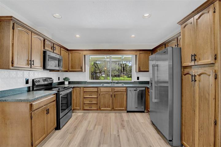 Wood cabinets with lazy susan corner cabinets, built-in pantry and window pass through counter to Lanai