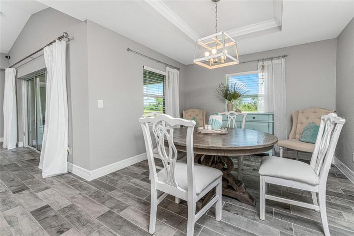 Dining area features a tray ceiling and crown moulding.