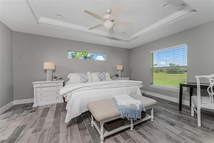 The Master bedroom has a tray celing with crown moulding and ceiling fan