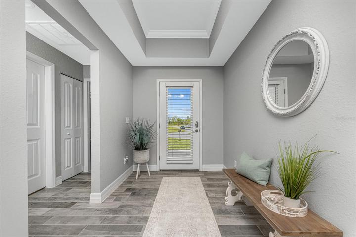 The foyer has a tray ceiling with crown moulding