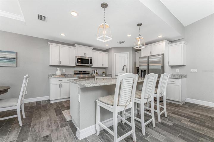 Kitchen features staggered height cabinetry with crown moulding