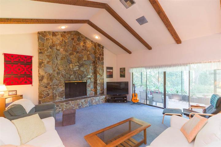 Living room with cathedral ceilings and wood burning fireplace.