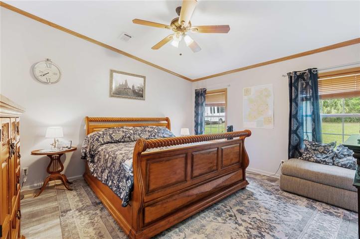Master bedroom has vinyl flooring, ceiling fan, double walk-in closet and ample space for a king bed.