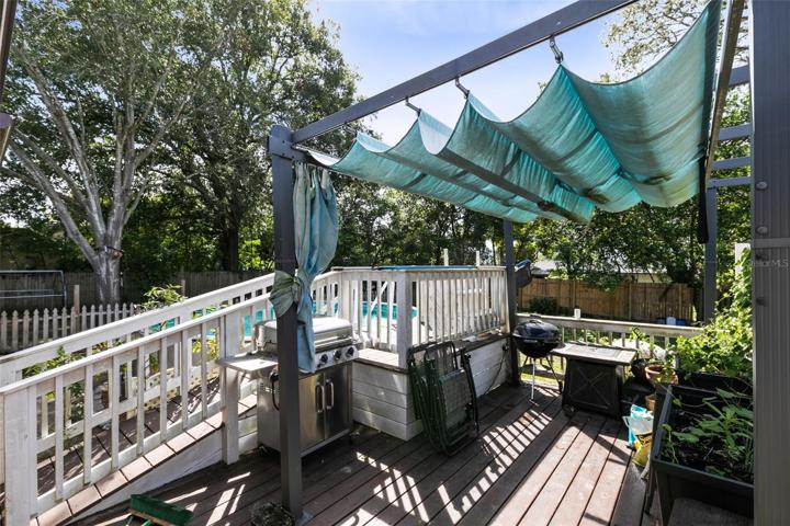 Beyond the screened lanai, a deck overlooks your sparkling above-ground pool, offering the perfect place to soak up the Florida sun.