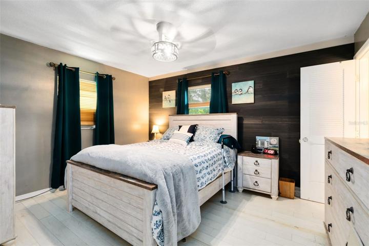 Back inside, you’ll find the master bedroom, just off the living room, features a charming wood accent wall.