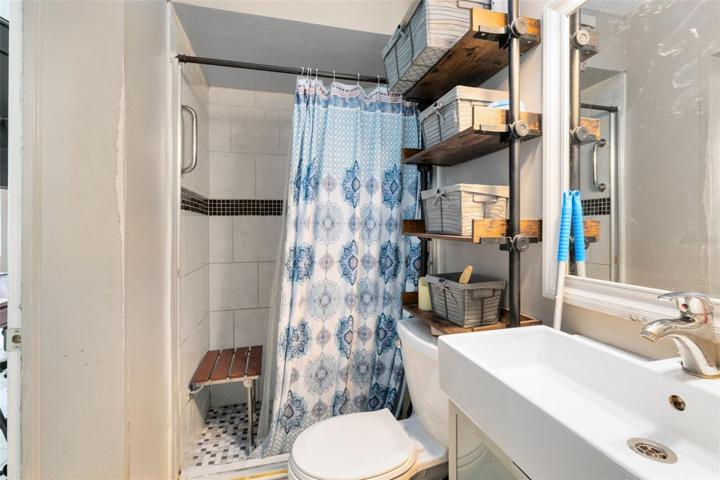 The master en suite bath, accessible from the living room, doubles as a guest bath and boasts a tiled walk-in shower for your convenience.