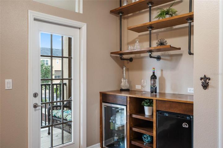 Built-in bar w/ mini fridge & wine fridge!  French door leads to the covered balcony!