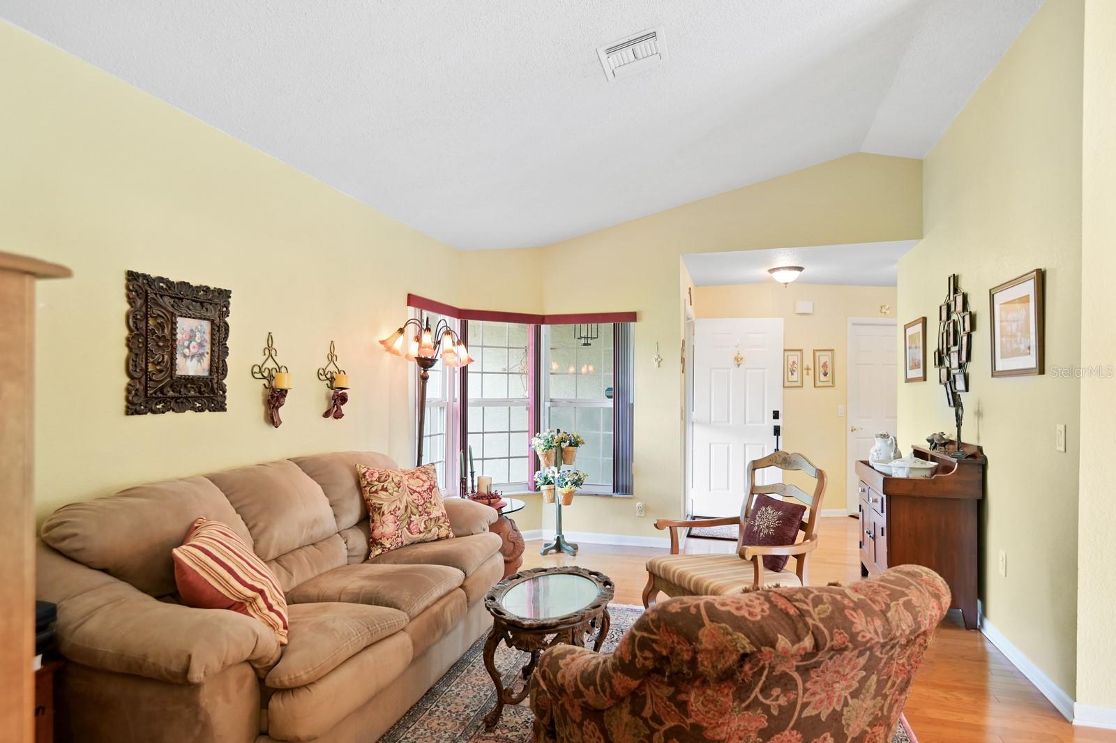 Living room with engineered hardwood flooring and vaulted ceiling.