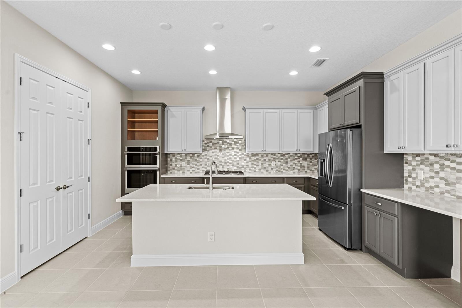 Gourmet kitchen, with gas cooktop, chimney hood, and built in oven/microwave combination.