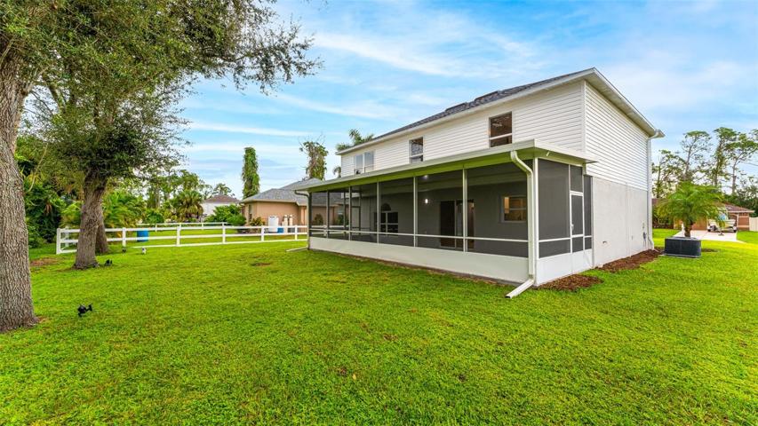 Rear view of home featuring huge screened porch and room for a pool