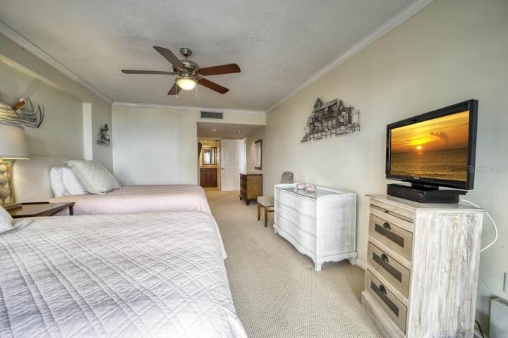 Guest bedroom with crown molding and a ceiling fan