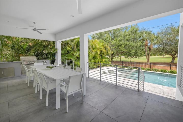 COVERED LANAI WITH BUILT-IN GRILL OVERLOOKING THE POOL AND GOLF COURSE
