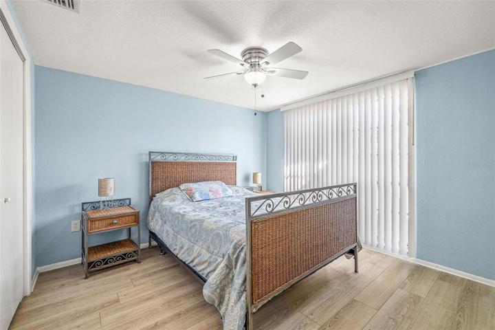 Bedroom 2 with easy clean laminate flooring, ceiling fair with nice paint tones.  Large enough for a Queen bed.