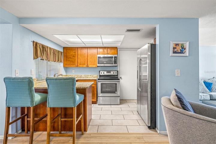 View into kitchen toward garage. Nice and bright with calming cool paint colors and large ceramic tiles in the kitchen.