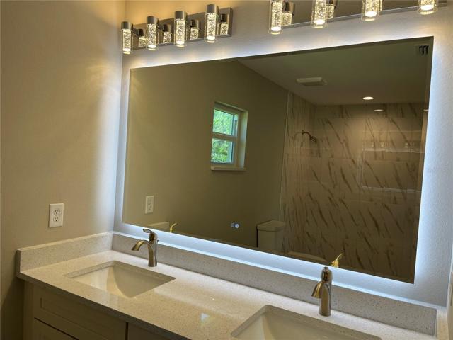 Master Bathroom with dual sinks and beautiful backlit mirror