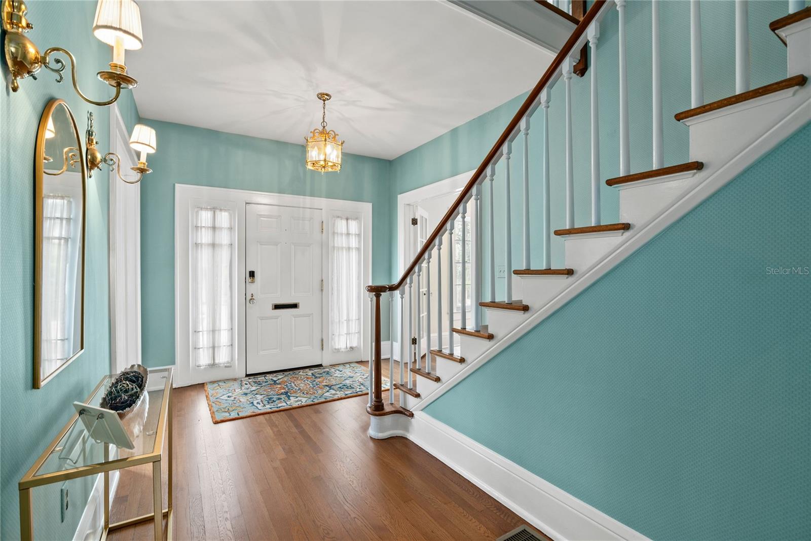 Stately foyer with high ceilings, lots of natural light and beautiful hardwood floors