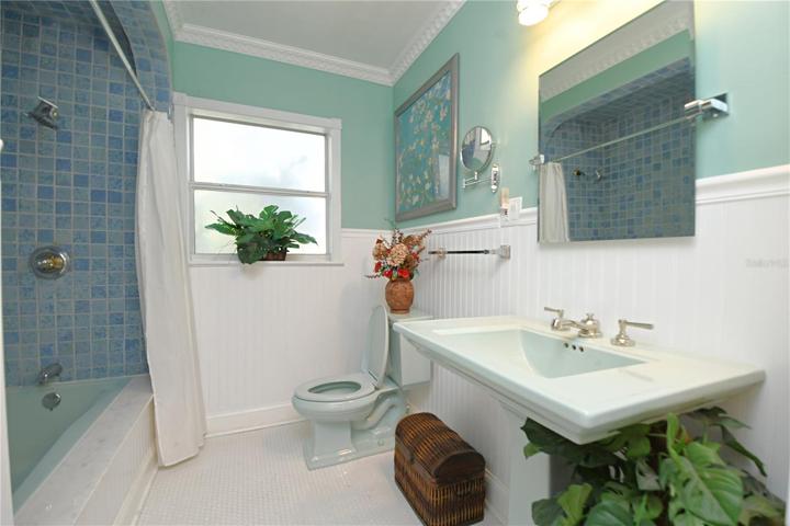 Bathroom #2 is very large (9x7) and it features a bathtub/shower combo, single pedestal bathroom sink and built in shelf that is not pictured in this photo.