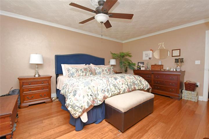 Another view of the Master bedroom that features hardwood bamboo flooring and decorative plaster ceiling with a fan/light.