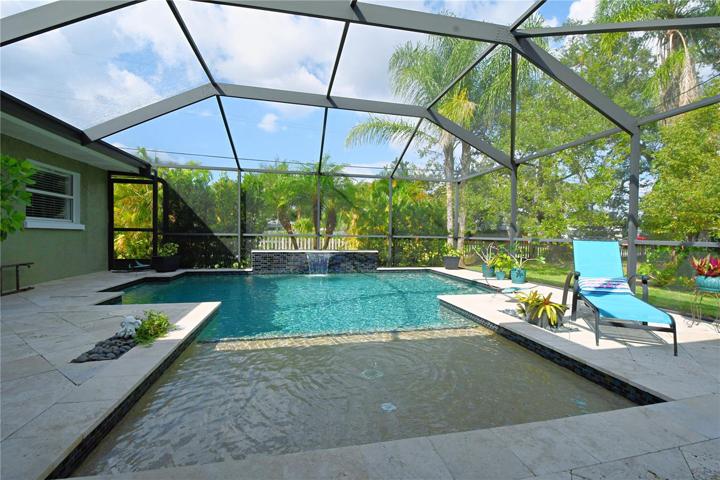 The pool also features a waterfall, 3 jets, and a sun shelf with a bubbler, creating a luxurious and tranquil space to unwind.