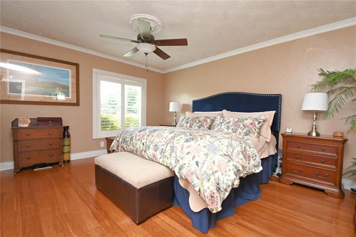 The master bedroom is a true retreat, featuring a spacious walk-in closet, crown molding, and large windows adorned with plantation shutters.