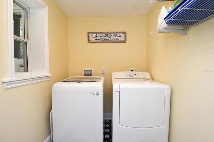 Laundry room features a window and built-in shelves.