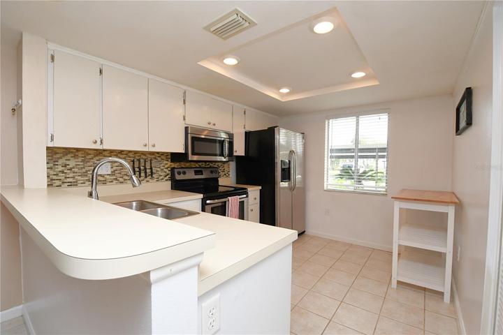 The Kitchen also features tray ceiling with recessed lights and a breakfast bar.