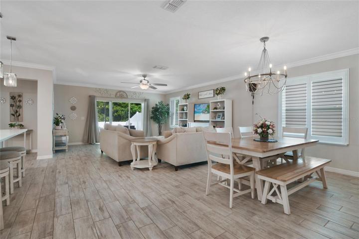 The kitchen is open to the living and dining areas where crown molding meets high ceilings and TRIPLE SLIDING GLASS DOORS give access to a SCREENED LANAI!