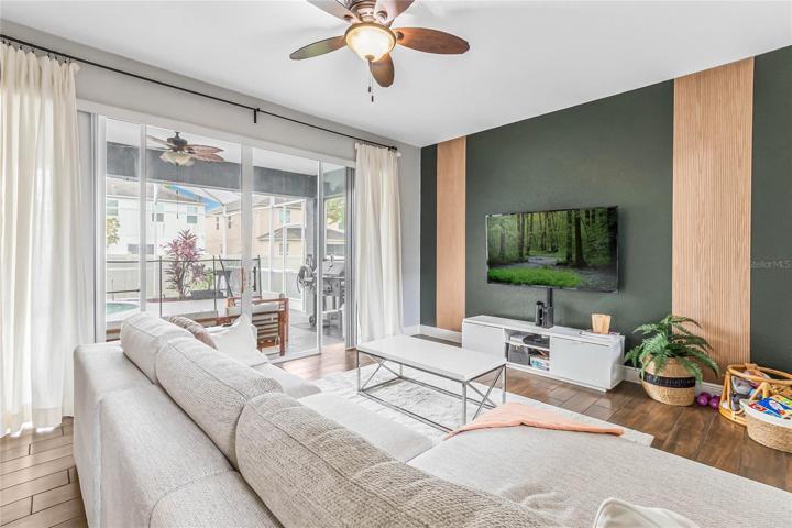 A chic accent wall and oversized sliding glass doors for access to the lanai and pool - indoor/outdoor living at its finest!