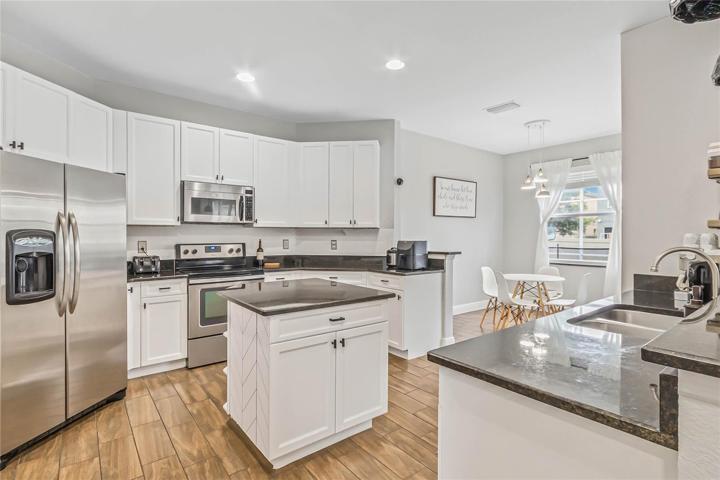 The family chef will appreciate the well equipped kitchen finished in a modern color palette, featuring STAINLESS STEEL APPLIANCES, granite counters and a bright and cheery breakfast nook with another set of doors to access the lanai!