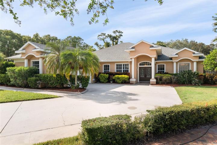 Front view , side load oversized 2 car garage, surrounded by mature trees