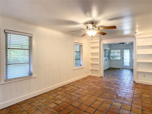 View of living room and front room from hall doorway. Notice the built in book shelves.