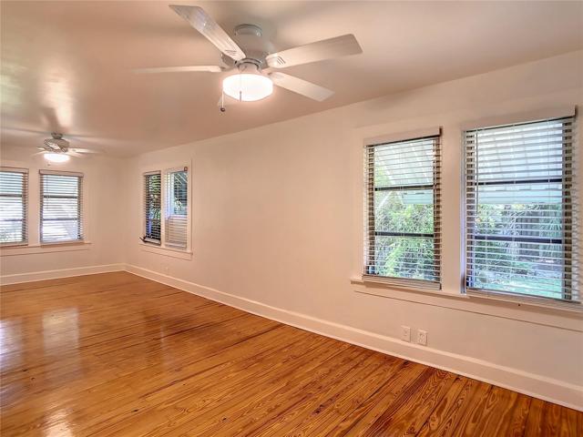 Primary bedroom. Windows to the left face south, overlook the front yard & street in the distance. 2 sets of windows to the right overlook side yard.