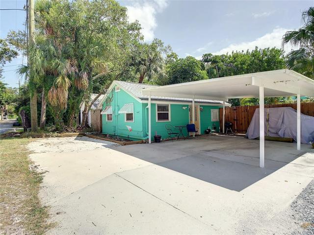 View of Studio cottage from alley. There is a parking area under those trees.