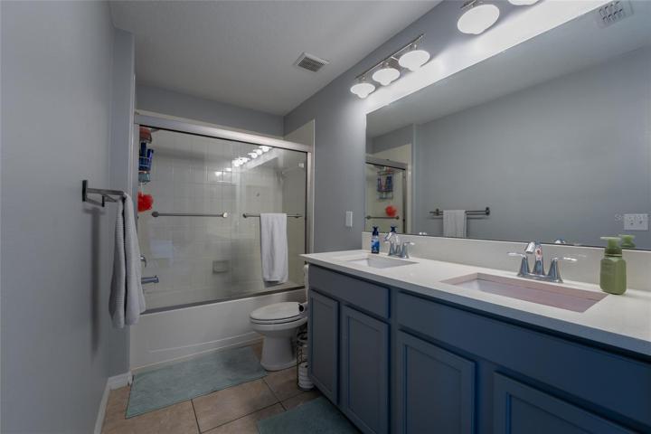 Jack and Jill bathroom with shower enclosure and two vanities.