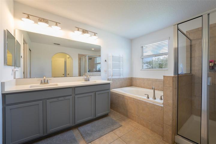 Master Bathroom with tub, shower enclosure and two vanities.