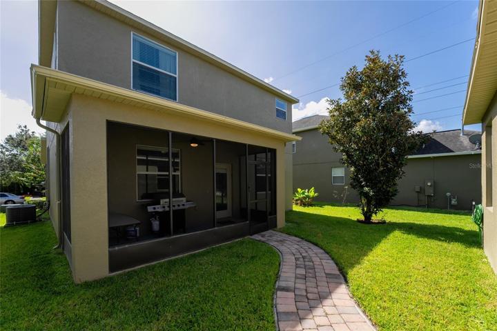 Back of the home showing pathway to garage and landscape.