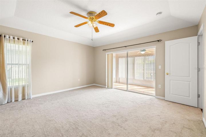 SPACIOUS MAIN BEDROOM WITH TRAY CEILINGS AND EXIT SLIDING DOORS LEADING TO THE FLORIDA ROOM!