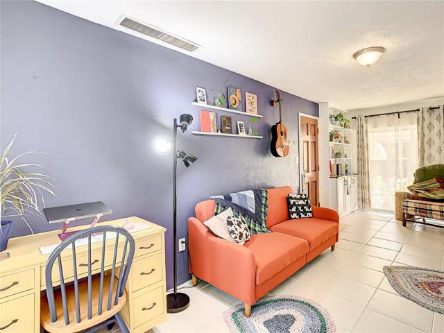 family room is light and bright with natural lighting coming from the floor-to-ceiling windows and the sliding glass doors that lead out to the back yard