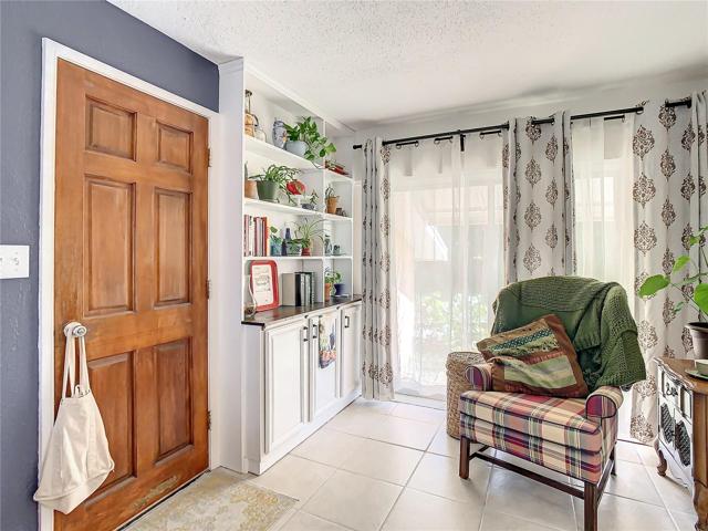 family room is light and bright with natural lighting coming from the floor-to-ceiling windows and the sliding glass doors that lead out to the back yard