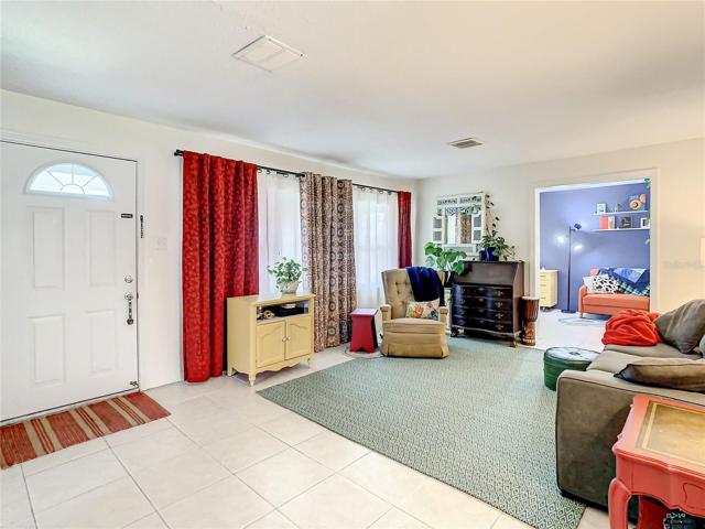 Enter the home through the formal living room that features large windows and easy maintenance tile flooring.