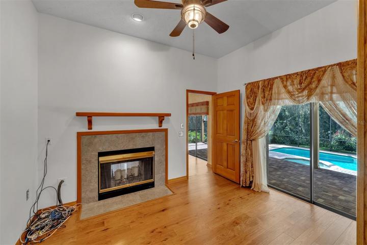 Den with view of the pool and access to the double sided fireplace
