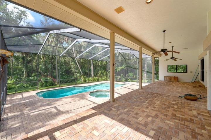 large lanai overlooking the wooded backyard.